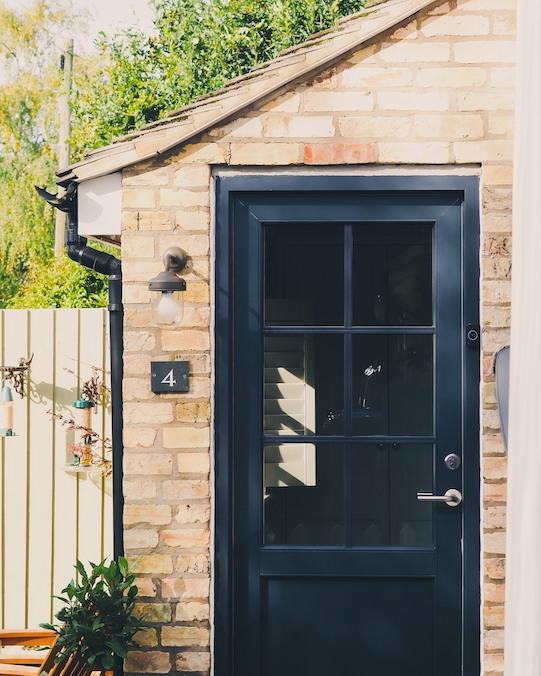 Image of black front door in yellow brick structure